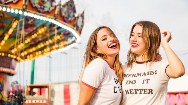 Portret van twee glimlachende jonge vrouw bij pretpark