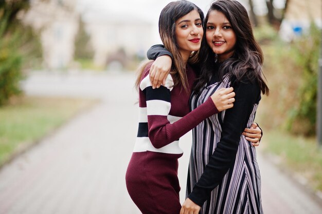 Portret van twee jonge mooie Indiase of Zuid-Aziatische tienermeisjes in jurk die samen op straat lopen