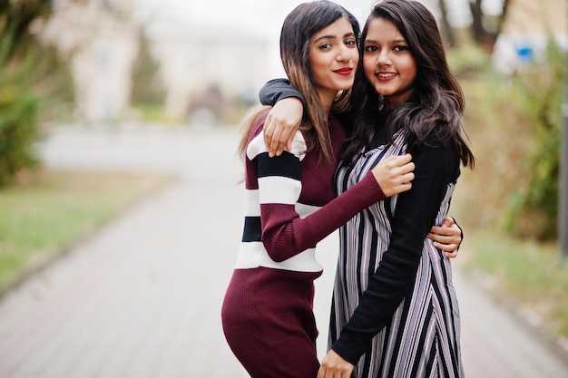 Portret van twee jonge mooie Indiase of Zuid-Aziatische tienermeisjes in jurk die samen op straat lopen