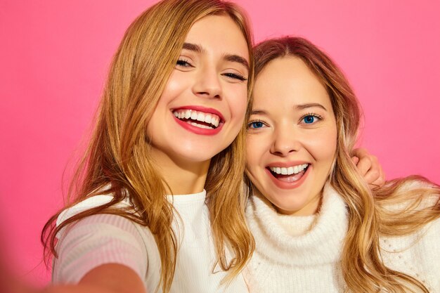 Portret van twee jonge stijlvolle glimlachende blonde vrouwen