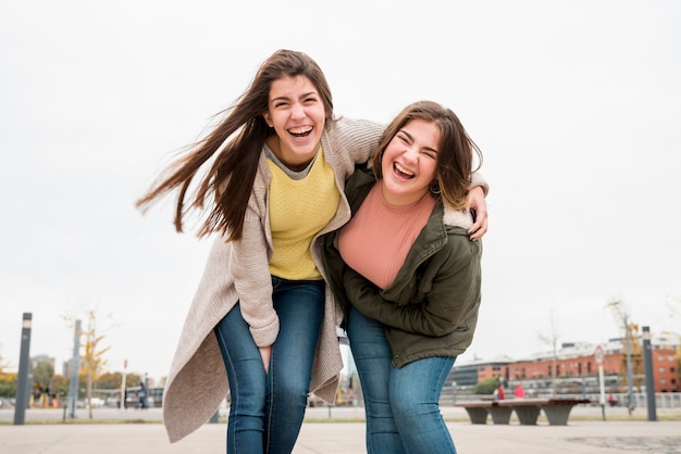 Portret van twee meisjes in stedelijke omgeving met plezier