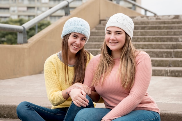 Portret van twee meisjes in stedelijke omgeving met plezier