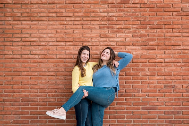 Portret van twee meisjes voor een muur