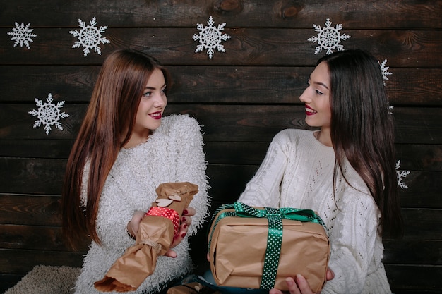Portret van twee vrij jonge vrouwen met Kerstmisgiften
