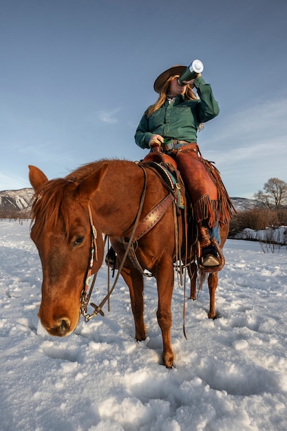 Gratis foto portret van veedrijfster op een paard