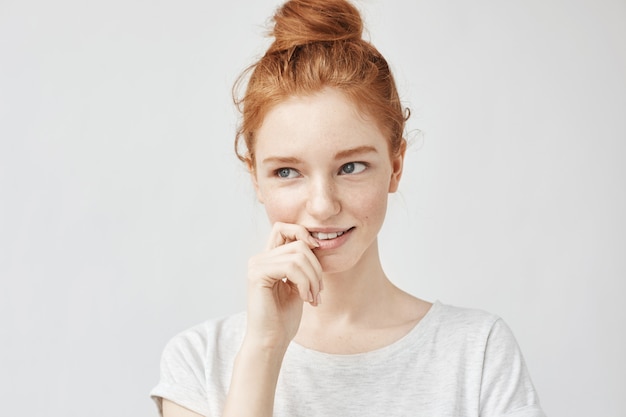 Portret van verlegen mooie vrouw met foxy haar en sproeten glimlachen.