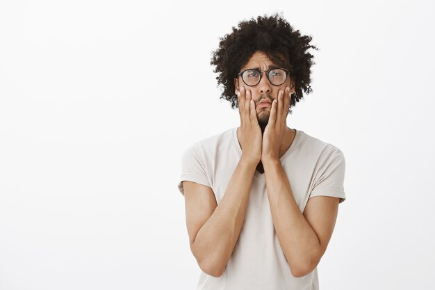 Portret van vermoeide en geïrriteerde man in glazen, rologen en gehinderd gezichtspalm