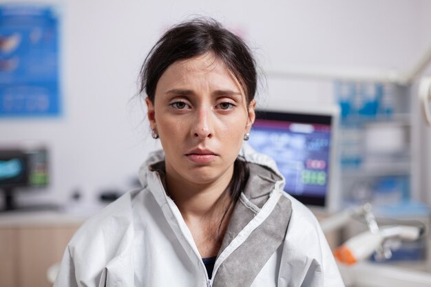 Portret van vermoeide tandarts in beschermende kleding tegen coronavirus