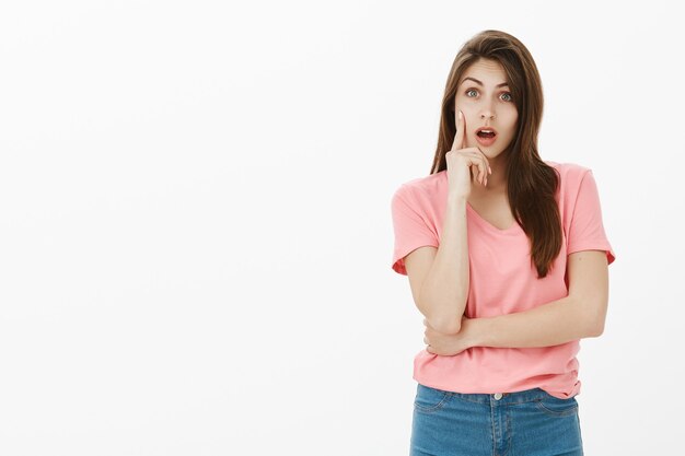 Portret van verrast brunette vrouw poseren in de studio