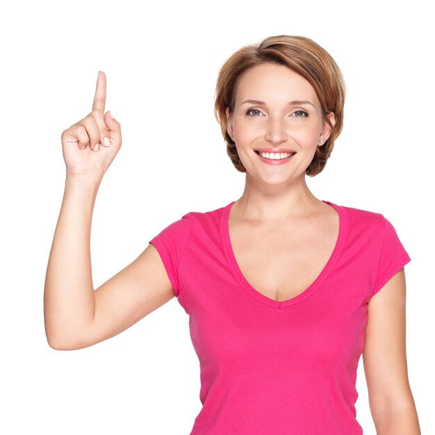 Portret van volwassen gelukkige vrouw die met haar vinger over witte ruimte benadrukt