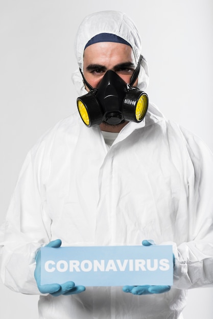 Gratis foto portret van volwassen mannelijk holding coronavirus teken