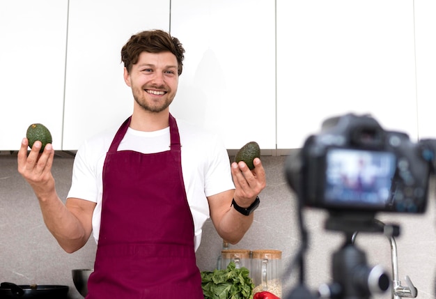 Portret van volwassen mannelijke bedrijf avocado's op camera