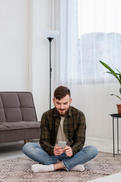 Portret van volwassen mannetje dat mobiele telefoon doorbladert