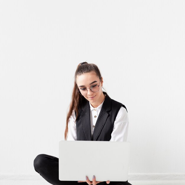 Portret van volwassen vrouw die op laptop werkt