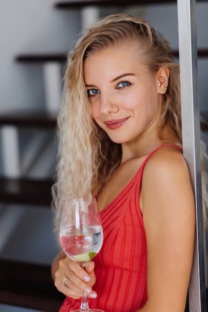 Portret van vrij jonge blanke vrouw met lichte natuurlijke make-up in rode minikleding