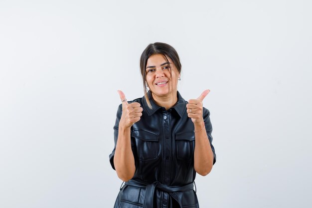 Portret van vrolijke Mexicaanse vrouw in leren jas duimen omhoog gebaar geven en glimlachen geïsoleerd op een witte achtergrond