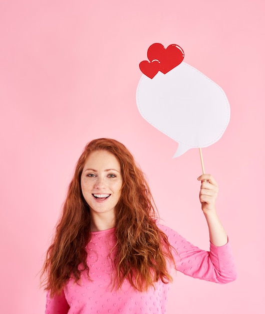 Portret van vrolijke vrouw met tekstballon bij studio-opname