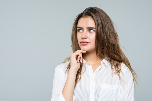 Portret van vrouw denken nadenkend kijken op kopie ruimte. Mooie jonge vrouw op een witte achtergrond