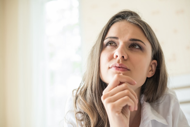 Portret van vrouw die bij het bed ligt