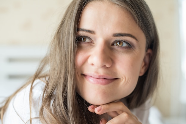 Portret van vrouw die bij het bed ligt