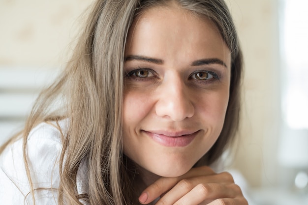 Portret van vrouw die bij het bed ligt