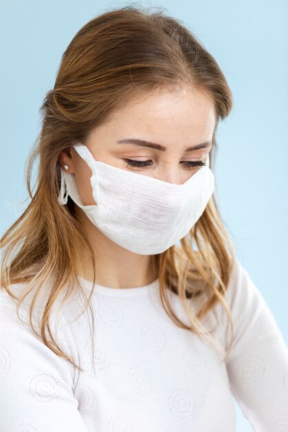 Portret van vrouw die een chirurgenmasker draagt