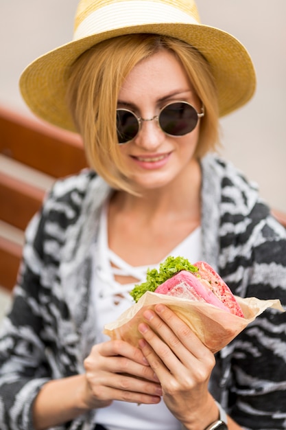 Portret van vrouw die haar sandwich bekijkt