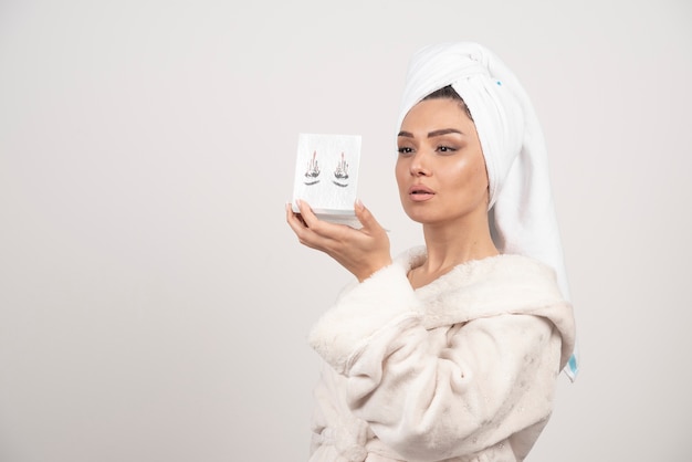 Portret van vrouw gewikkeld in witte handdoek met oogschaduw palet