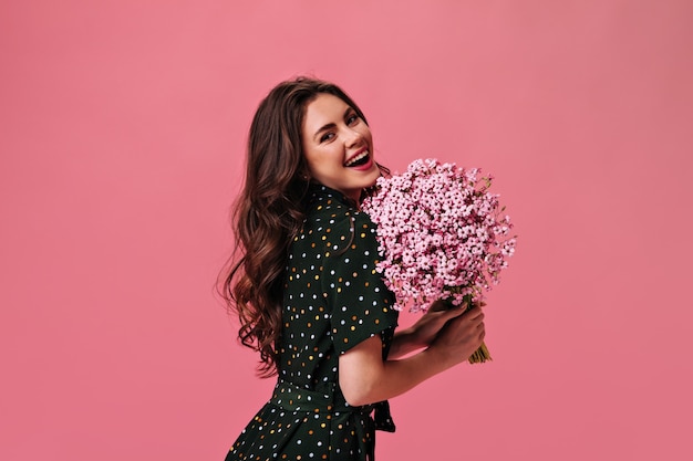 Portret van vrouw met boeket op roze muur