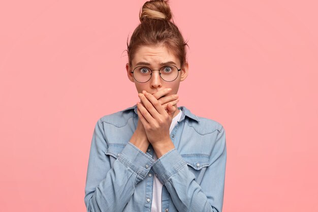 Portret van vrouw met haar in een broodje en het dragen van denimoverhemd