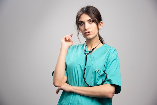 Portret van vrouwelijke arts met een stethoscoop op grijs