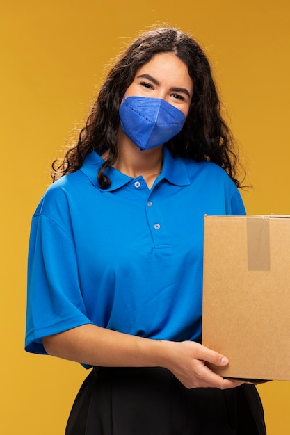 Portret van vrouwelijke bezorger met medisch masker op