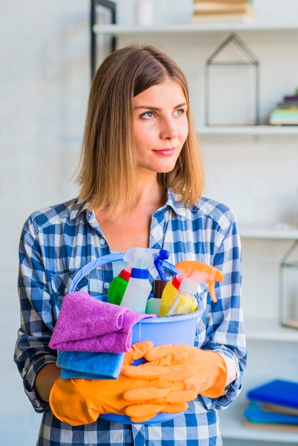 Portret van vrouwelijke conciërge bedrijf reinigingsapparatuur in de emmer