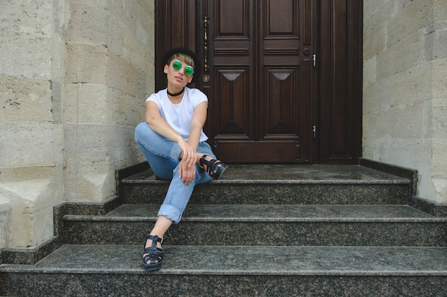 Portret van vrouwelijke hipster met natuurlijke make-up en kort kapsel die in openlucht van vrije tijd genieten