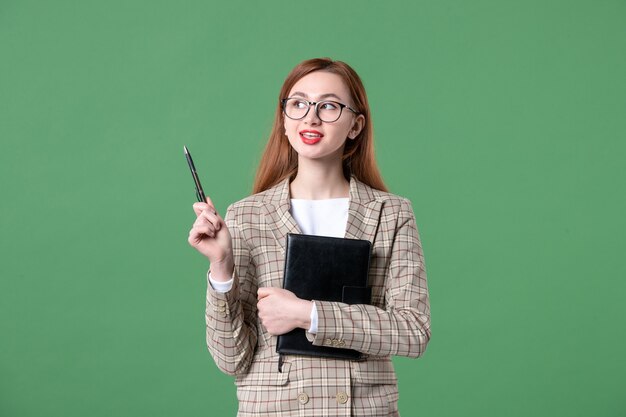 Portret van vrouwelijke leraar in pak op groen