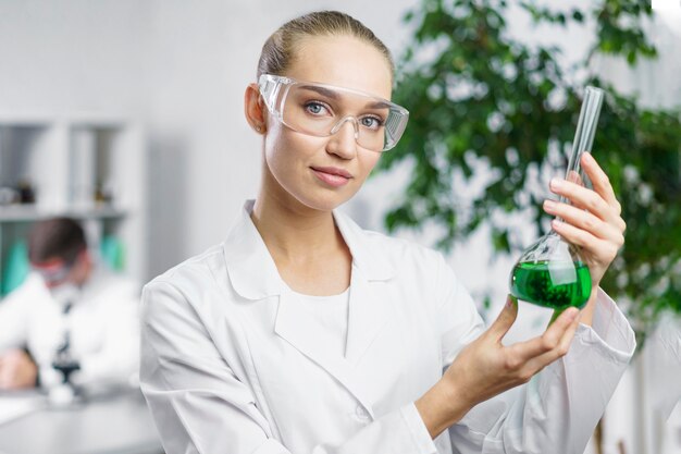 Portret van vrouwelijke onderzoeker in het laboratorium met reageerbuis