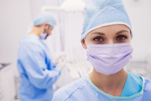 Portret van vrouwelijke tandarts die chirurgisch masker draagt