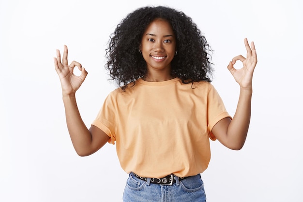 Portret van zelfverzekerde glimlachende Afro-Amerikaan die een goed gebaar toont