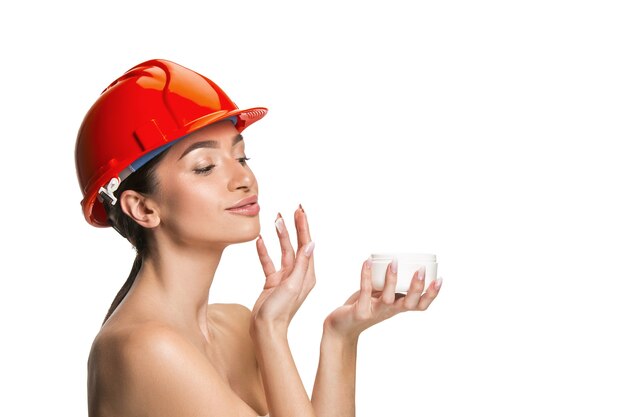 Portret van zelfverzekerde vrouwelijke gelukkig lachende werknemer in oranje helm