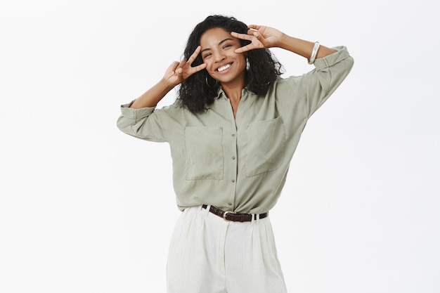 Portret van zorgeloze charmante en vrolijke jonge Afro-Amerikaanse succesvolle vrouw in blouse en broek