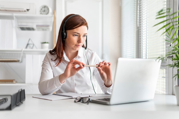 Portret vrouw aan het werk met video-oproep op laptop