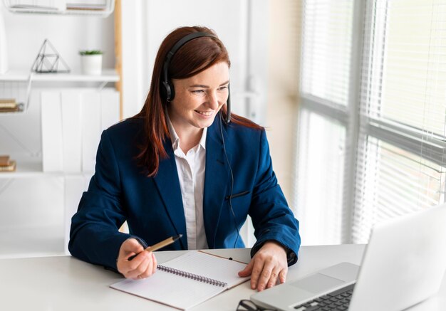 Portret vrouw aan het werk met video-oproep op laptop