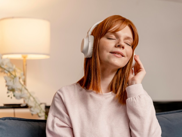 Portret vrouw thuis luisteren muziek