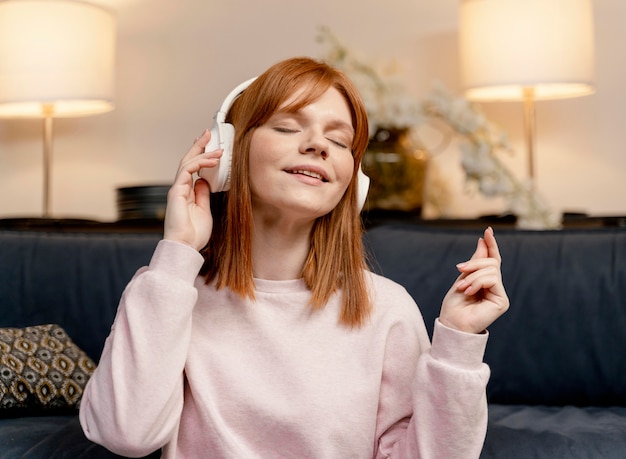 Gratis foto portret vrouw thuis luisteren muziek