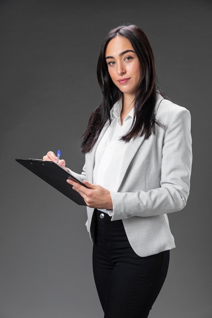 Portret vrouwelijke advocaat in formeel pak met klembord