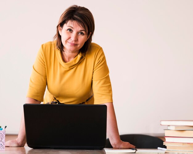 Portret vrouwelijke leraar met laptop