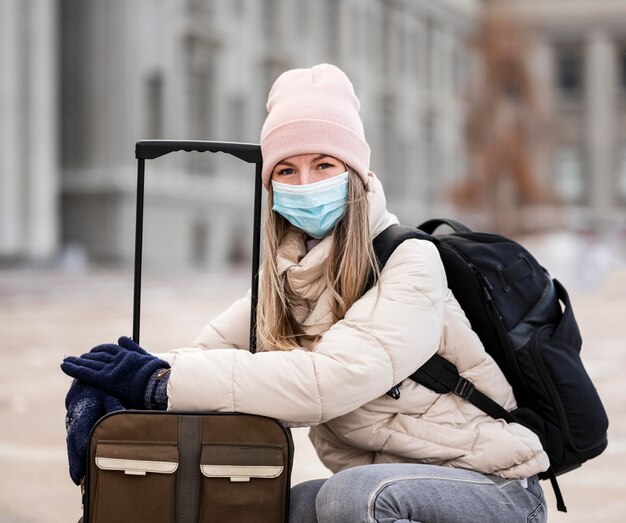 Portret vrouwelijke student masker dragen en bagage dragen