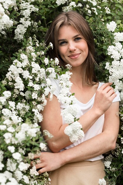 Portretvrouw het stellen in bloemen