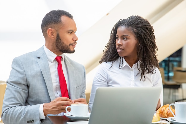 Positieve jonge collega's die ideeën voor project bespreken