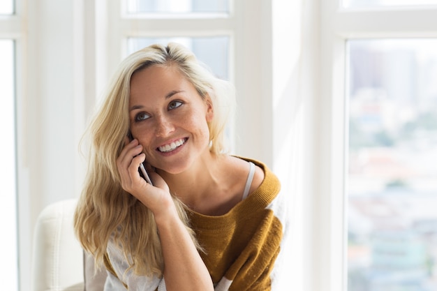 Positieve jonge vrouw praten op de mobiele telefoon